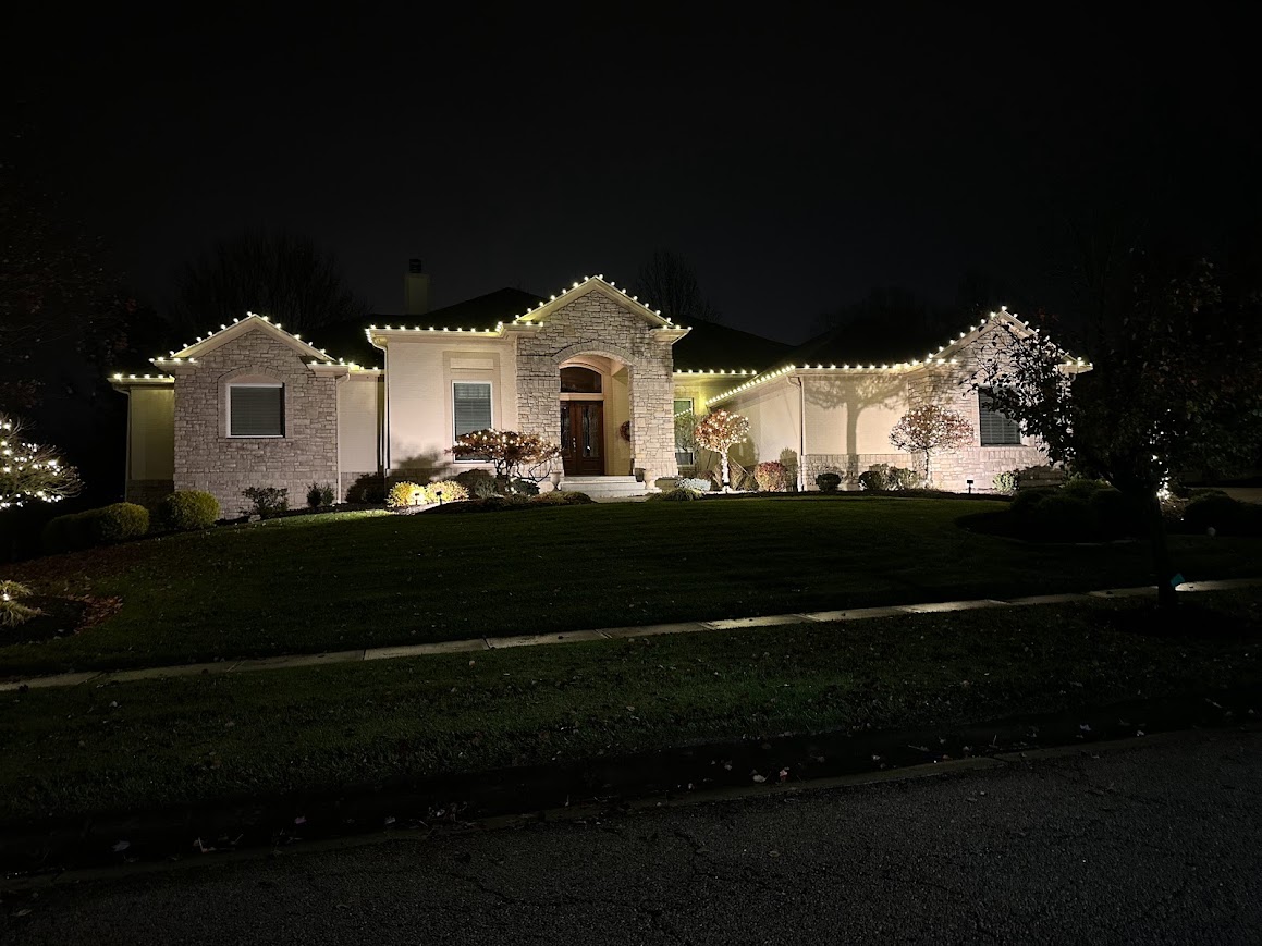 Clean warm white roofline lighting on a stone ranch home at night